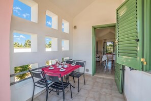 A dining area with a red tablecloth, black chairs, and a view through the open door. - Borgo Primizia M17 Pool And Sea, Otranto, Italy (Otranto)