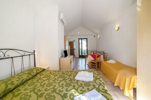 Ein Schlafzimmer mit einem Bett, einem Schreibtisch, einem Stuhl und einem Tisch mit gelber Tischdecke.