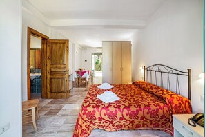 Una camera da letto con un letto, un'armadiatura in legno e un piccolo tavolo.
