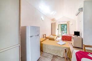 A compact hotel room with a bed, a small table, a television, and a refrigerator. - Borgo Primizia M11 Pool And Sea, Otranto, Italy (Otranto)
