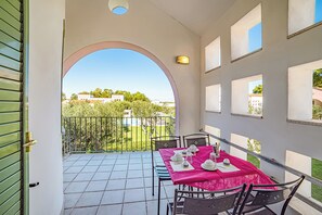 A balcony with a table set for two, a view of the surrounding area, and a door leading to the balcony. - Borgo Primizia M11 Pool And Sea, Otranto, Italy (Otranto)