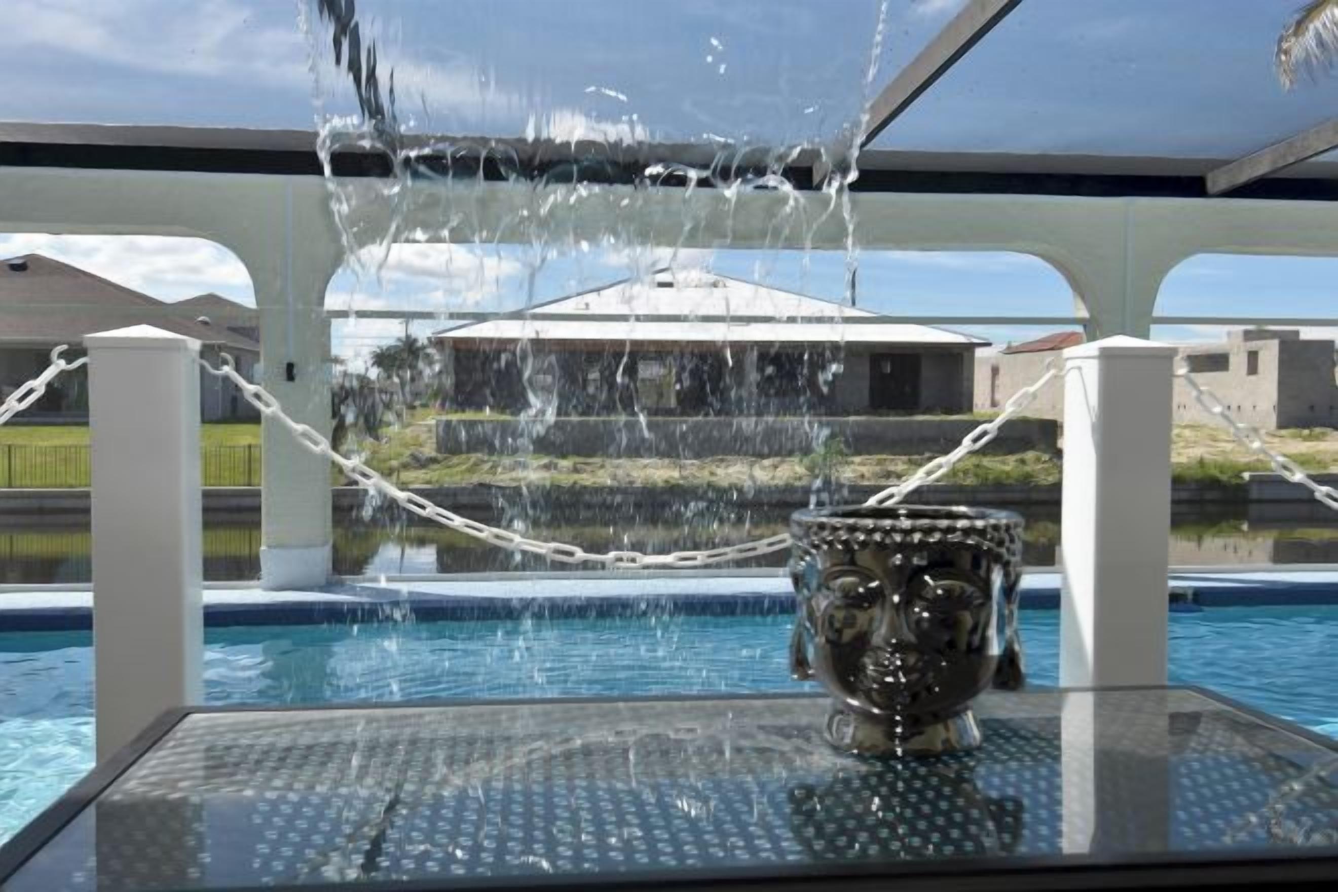 A pool with a water feature and a decorative urn.