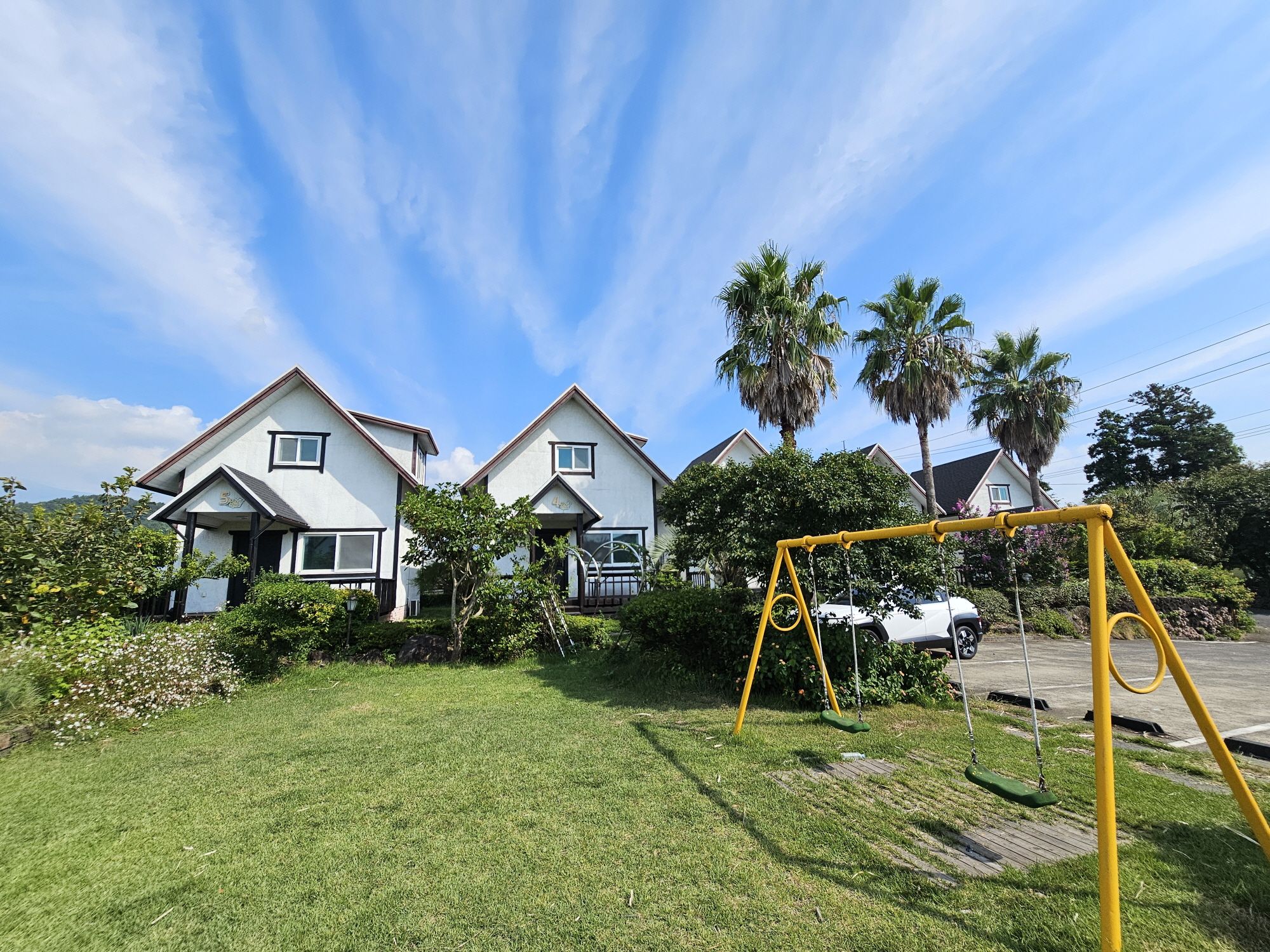 Zona residencial con casas, un jardín césped y un columpio.