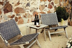 Outdoor wicker furniture with a table, a wine bottle, and a glass. - Shepherds Cottage at Lisdillon Estate (Little Swanport)