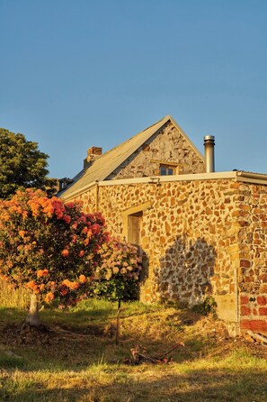 Un edificio de piedra con techo a dos aguas y chimenea.