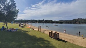 A lakeside park with picnic areas, a wooden structure, and a clear view of the lake.