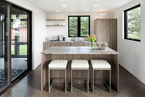 Een koelkast, een vaatwasser, kookgerei, borden en bestek, een eettafel