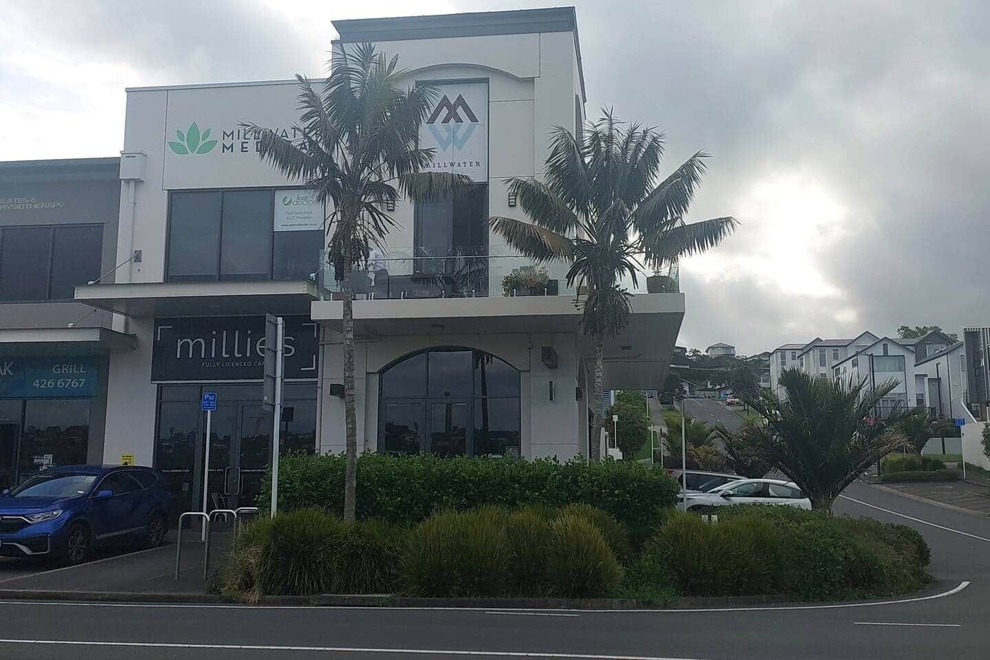 A modern building with a sign for 'Millies' and a 'Grill' sign visible.