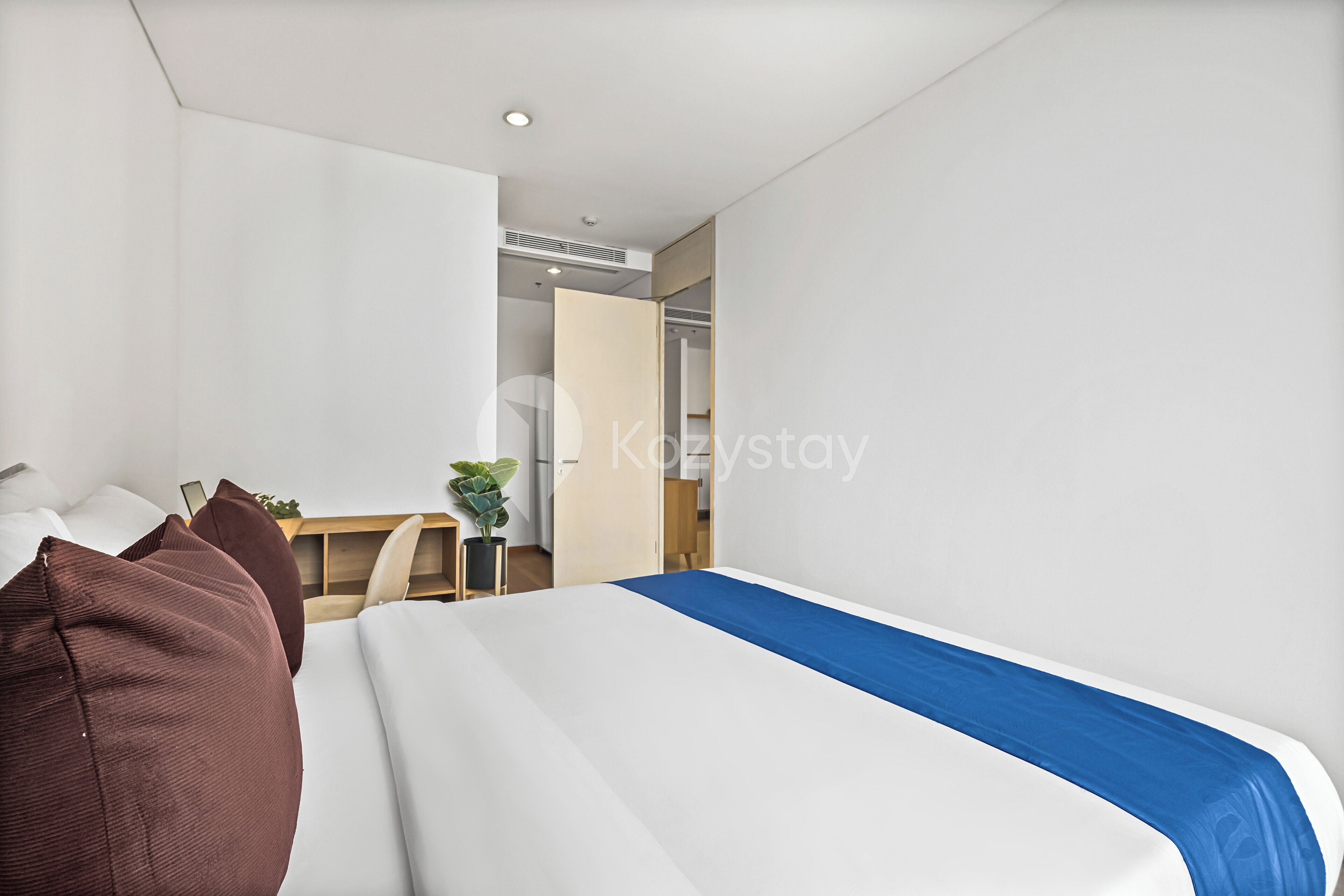 Habitación de hotel moderna con cama, escritorio y armario.