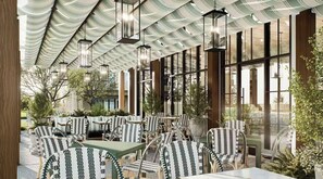 A covered outdoor seating area with patterned chairs and tables, large windows, and hanging lanterns. - Luxury Condo - Prime Location -Ideal Mid-term Rental (Rogers)