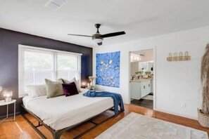 A bedroom with a bed, a ceiling fan, a window, and a view into the kitchen. - 5/2 (two kings), fireplace, hot tub, firepit (Blanco)