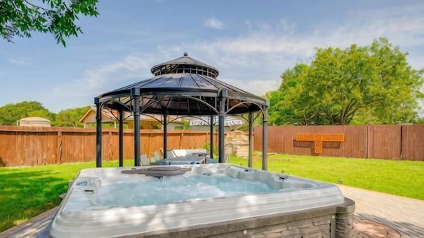 Een hottub met een overkapping in een achtertuin.
