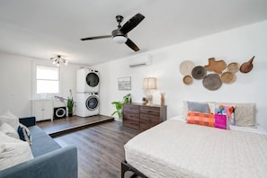 A bedroom with a bed, a ceiling fan, a washing machine, and a dresser. - 5/2 (two kings), fireplace, hot tub, firepit (Blanco)