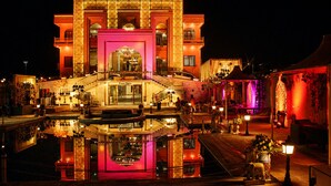 A hotel with a central entrance, a pool, and a well-lit facade. - Hotel Ratan Mahal Palace (Ratangarh)