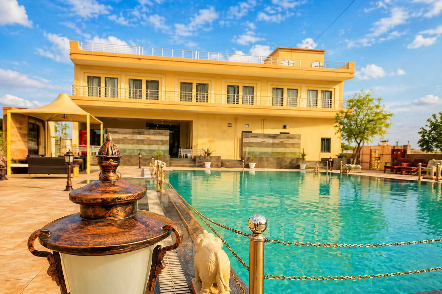 Ein Hotel mit Schwimmbecken, einer Fontäne und einem Gebäude mit zahlreichen Fenstern.