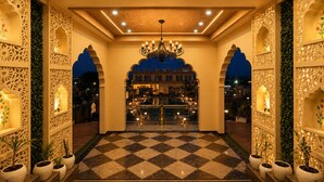 A hotel lobby with a checkered floor, ornate walls, and a chandelier. - Hotel Ratan Mahal Palace (Ratangarh)