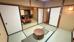 A traditional Japanese room with tatami flooring, a low wooden table, and sliding doors. - Livemax Resort HidaTakayama GaryunoSato (Takayama)