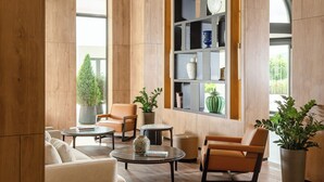 A modern lounge area with a sofa, armchairs, a coffee table, and a bookshelf. - Aghdam City Hotel (Aghdam)