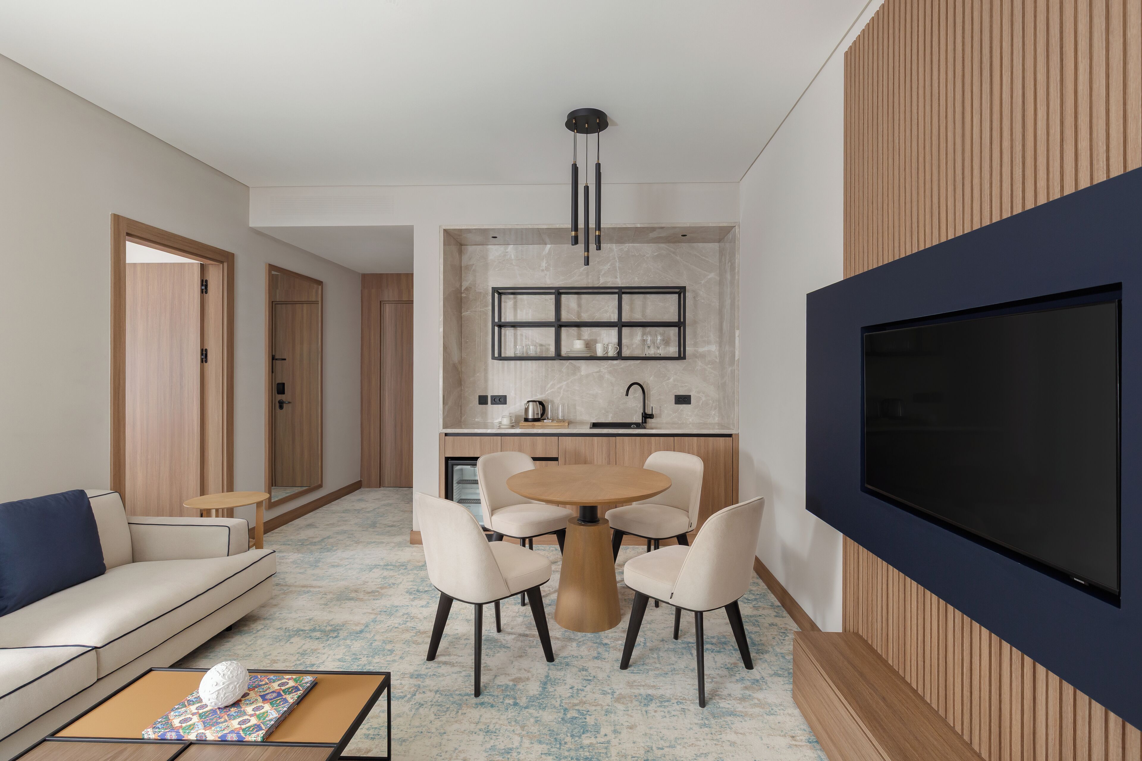 A modern living room with a sofa, coffee table, and a TV wall unit.