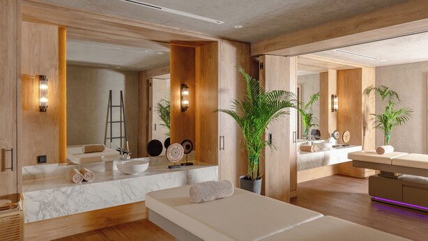 A modern spa room with a large mirror, wooden paneling, a massage table, and a marble sink. - Aghdam City Hotel (Aghdam)