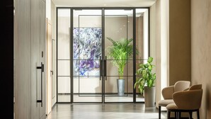 A modern lobby with a glass door, potted plants, and a seating area. - Aghdam City Hotel (Aghdam)