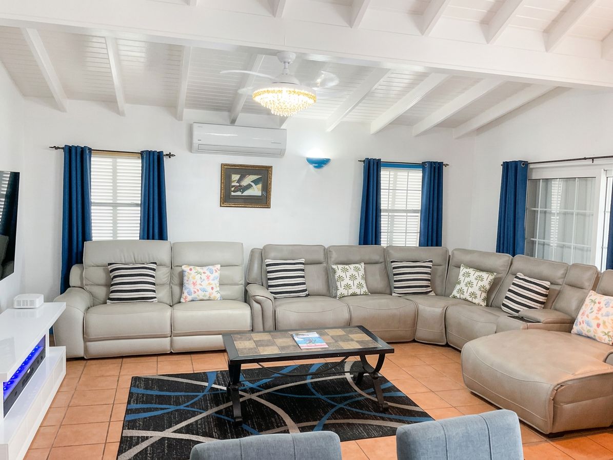 A living room with a sectional sofa, a coffee table, and a television.