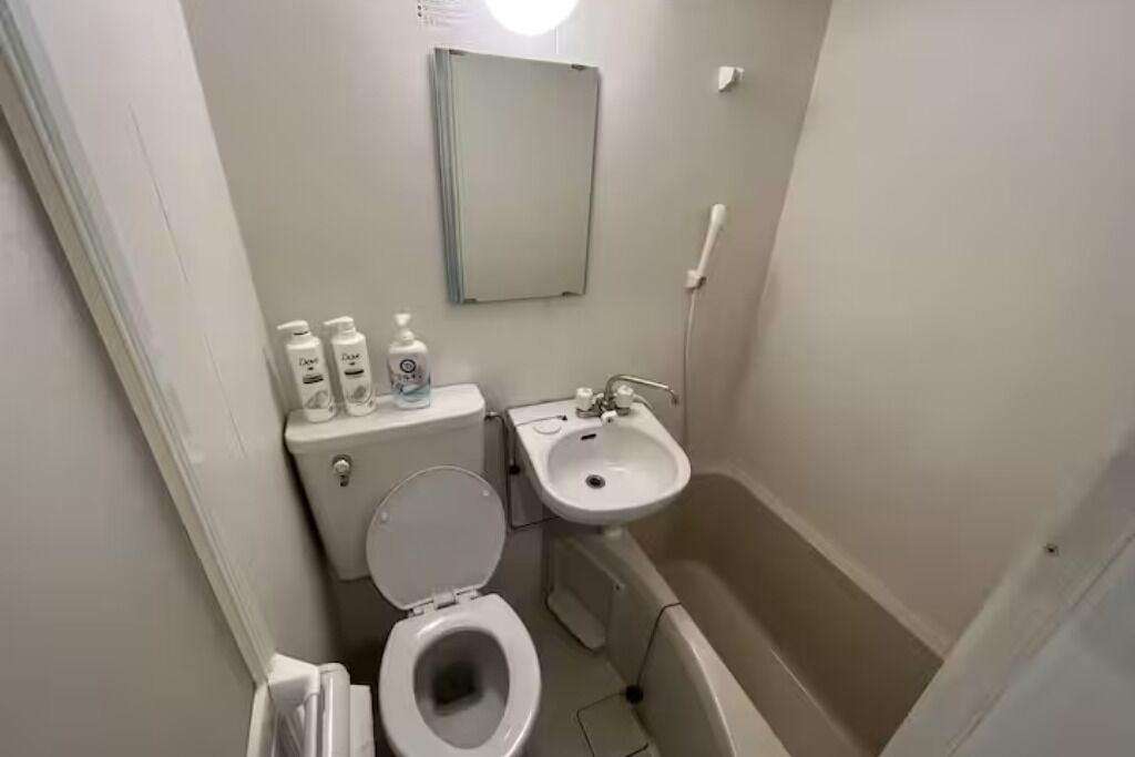 A small, compact bathroom with a toilet, sink, and bathtub.