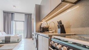 Una cocina moderna con horno integrado, cafetera y hervidor.