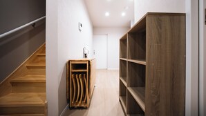 A hallway with wooden stairs, a wooden cabinet, and a wooden shelving unit. - TEN6-TenSix- (Osaka)