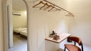 A compact room with a bed, a chair, a desk, a mirror, and a clothes drying rack. - ONE18 Boutique Hotel - Kuala Lumpur (Kuala Lumpur)