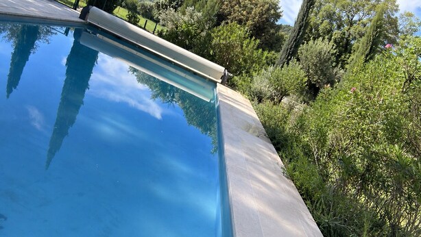 Una piscina con vista aperta sul verde circostante e una recinzione.