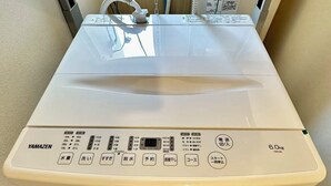 Yamazen-merkkinen pyykinpesukone, jossa on digitaalinen näyttö, ohjauspaneeli ja 6,0 kg:n täyttömäärän merkintä.