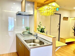 A modern kitchen with a stainless steel sink, wooden cabinets, and a built-in oven. - H302 *[New] Luxury Home in Tokyo | Japanese-style 2LDK | Honjo-Azumabashi Station & Direct Access to the Airport | Near Asakusa & Sky Tree (Sumida Ward)