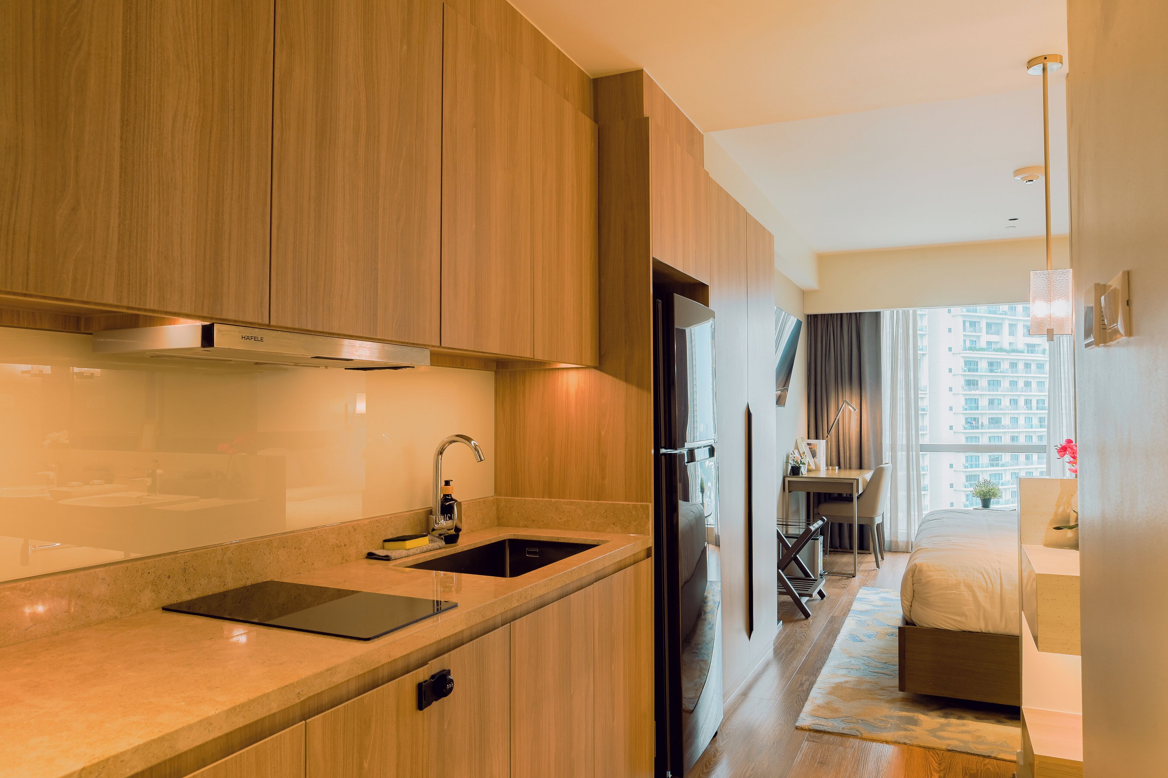 A modern kitchen with wooden cabinets, a built-in stove, and a sink.