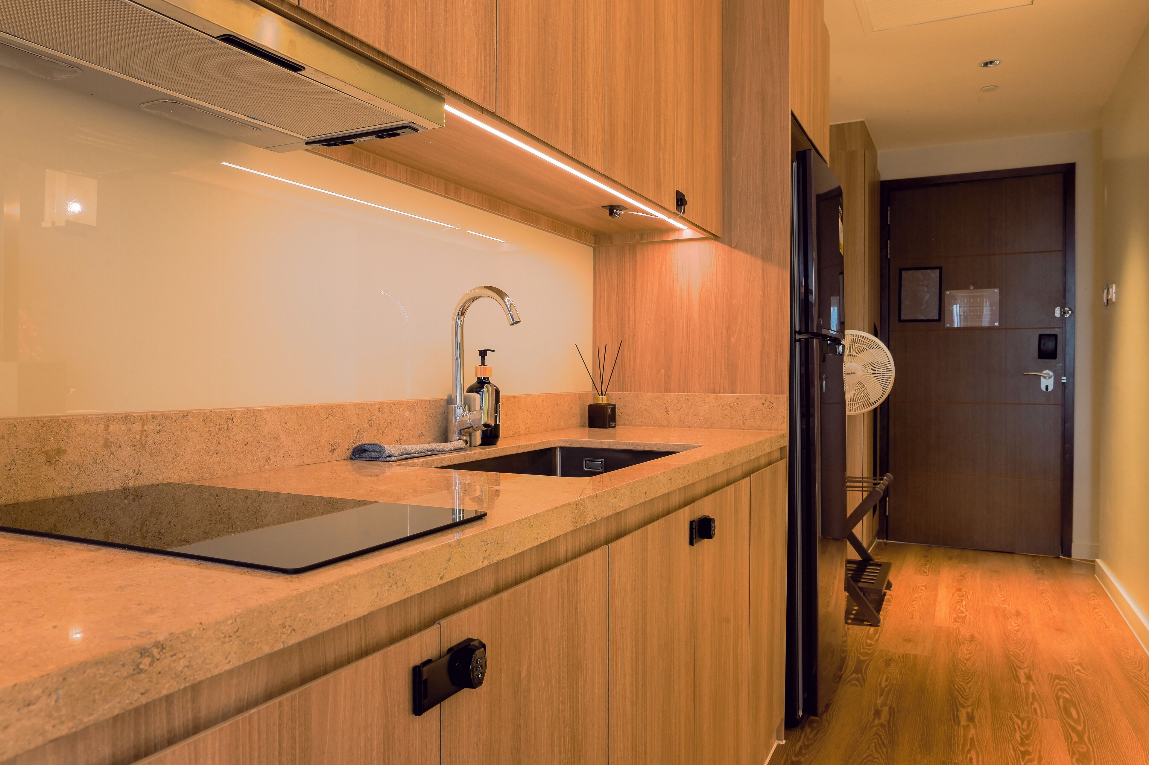 Een moderne keuken met een dubbele spoelbak, een inbouwoven en een kastontwerp van hout.
