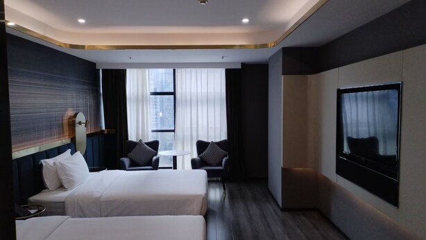 A hotel room with two beds, a TV, a small table, and a window with curtains. - Chongqing Justom Hotel Branch 3 (Chongqing)
