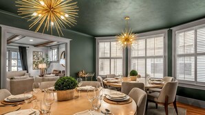 A dining area with round tables set for six, each with plates, cutlery, and wine glasses. There are two pendant lights above the tables. - Hot Tub | Firepit | Putting Green | 5 Bedrooms (Shelbyville)