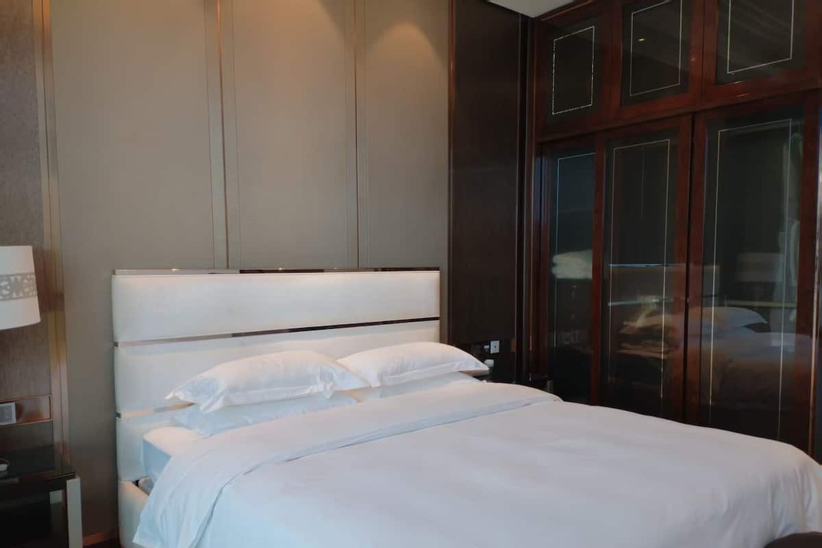 Un letto rifatto con lenzuola bianche in una camera d'albergo.