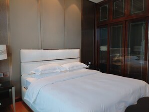 A neatly made bed with white linens in a hotel room. - Chongqing Justom Hotel Branch 1 (Chongqing)