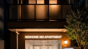 The entrance to Sidihome 365 Apartment with a vending machine and bicycles outside. - Sidihome 365 Apartment (Osaka)
