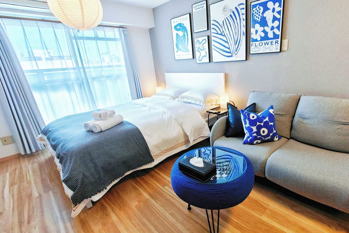 Ein Hotelzimmer mit Bett, einer Couch, einem runden Tisch und Bildern an der Wand.