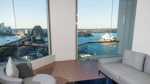 A modern living room with a large window offering views of a bridge and a famous opera house. - Fantastic city-view home in the Rocks (The Rocks)
