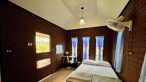 A room with a bed, a desk, a chair, a fan, and a window with curtains. - Bansuan Banjong Akkson (Klaeng)