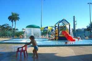 A water park with a water slide, a water fountain, and a red chair. - Casagrandesouthbeach by AmericanVacationLiving 4Rm (Miami Beach)
