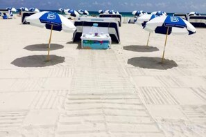 A beach with rows of umbrellas and a table with a tablecloth. - Casagrandesouthbeach by AmericanVacationLiving 4Rm (Miami Beach)