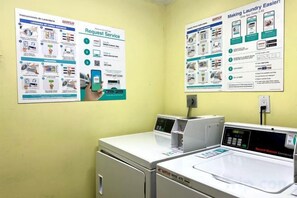 A laundry room with a washing machine, dryer, and instructional posters on the walls. - Casagrandesouthbeach by AmericanVacationLiving 4Rm (Miami Beach)