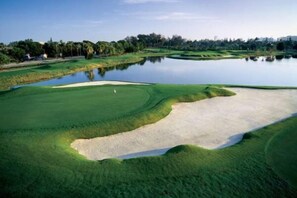A golf course with sand bunkers, water hazards, and a clear sky. - Casagrandesouthbeach by AmericanVacationLiving 4Rm (Miami Beach)
