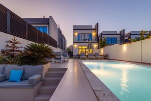A modern outdoor pool area with a built-in seating area and a staircase leading to a second level.