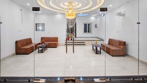 Eine moderne Lobby mit zwei Sofas, einem Chandelier und einer Glaskonstruktion.