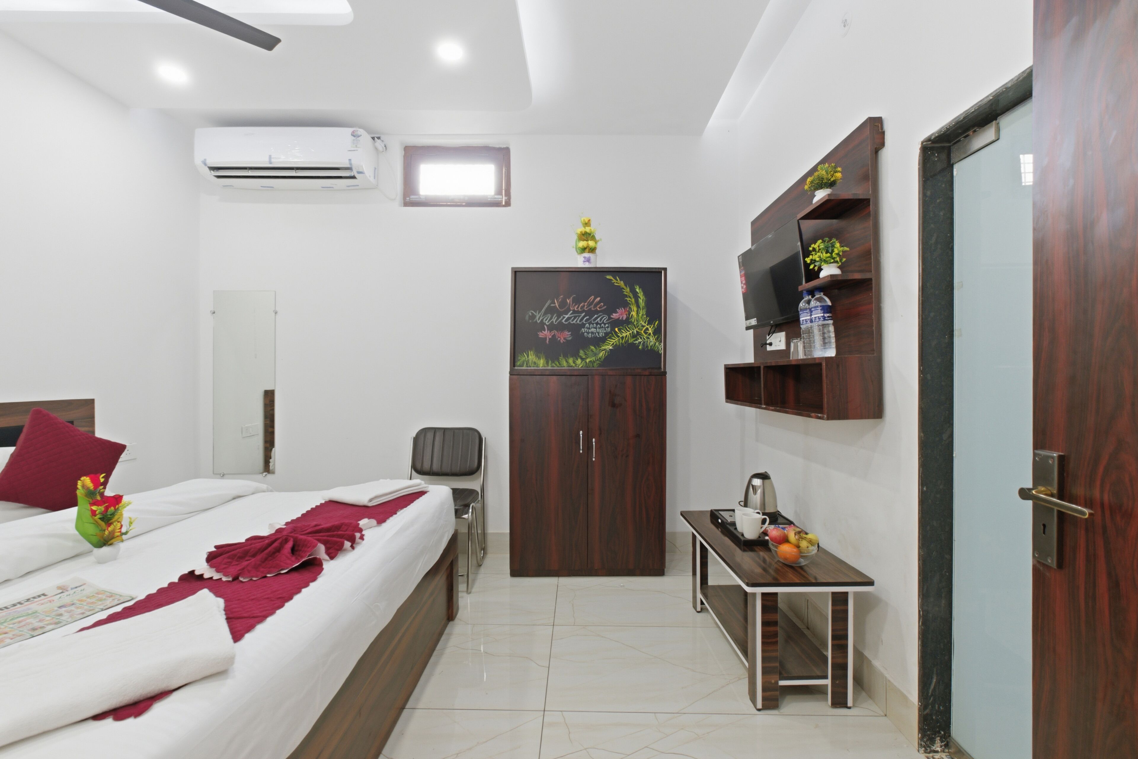 Habitación de hotel con cama, escritorio, armario, televisor y aire acondicionado.